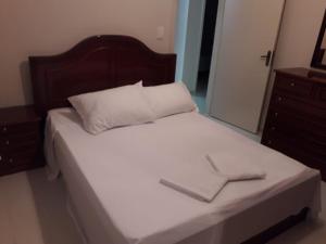 a bed with white sheets and a wooden headboard at Serra Gaúcha Uva e Vinho in Bento Gonçalves