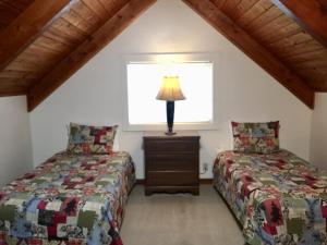 two beds in a attic bedroom with a window at Chalet at Mt. Rainier in Ashford