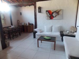 ein Wohnzimmer mit einem Sofa und einem Tisch in der Unterkunft Búzios Casa de Família - Bosque de Geribá in Búzios