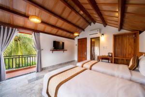 two beds in a bedroom with a balcony at Lama Beach Villa in An Bang