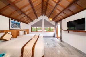 a bedroom with two beds and a flat screen tv at Lama Beach Villa in An Bang