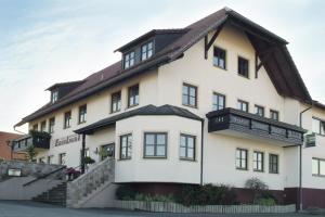 a large white house with a gambrel roof at Hotel - Restaurant Eberlwirt in Bruckberg