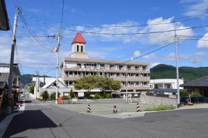 una calle con un edificio con un campanario rojo en 宇和パークホテル, en Seiyo