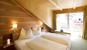シェーナにあるmittendorf klimaresidenceのベッドルーム(大きな窓、白いベッド付)