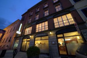 a building with large windows on a city street at Hotel San Donnino in Fidenza