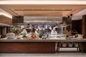 a kitchen with two chefs preparing food in a restaurant at Hyatt Regency Shanghai Wujiaochang in Shanghai