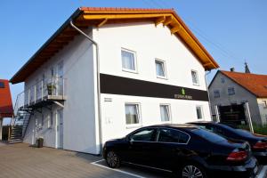 un coche negro estacionado frente a un edificio blanco en Business Homes - Das Apartment Hotel, en Lauchheim