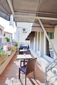 un patio al aire libre con mesas y sillas en un edificio en Azur Hotel, en Balaruc-les-Bains