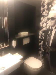 un uomo con gli occhiali da sole in bagno con servizi igienici di Hotel Am Volksgarten a Dusseldorf