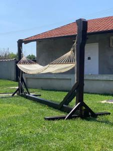 a hammock on the grass in front of a house at Alex Lodge in Zrenjanin