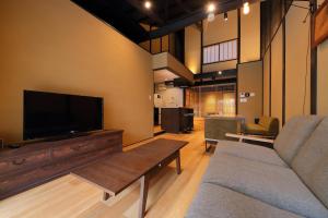 een woonkamer met een bank en een flatscreen-tv bij Kyo no oozora SAIKA in Kyoto