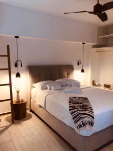 a bedroom with a large white bed with a ceiling at Hotel Acropol in Parga