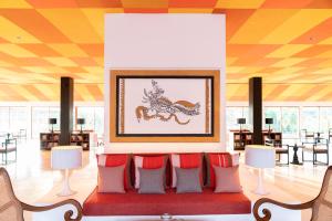 a waiting room with red chairs and a picture of a horse at Cinnamon Bentota Beach - Signature Selection in Bentota