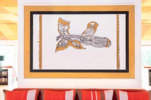 a framed picture of two birds on a branch at Cinnamon Bentota Beach - Signature Selection in Bentota