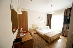 a hotel room with a bed and a desk at Hotel Confort in Cluj-Napoca