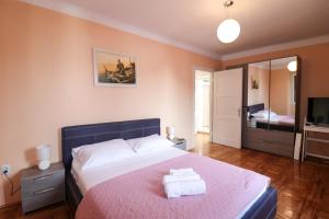 a bedroom with a large bed with a pink blanket at Dida Boža House in Vodice