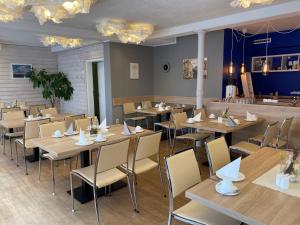 a dining room with wooden tables and chairs at Hotel-Pension Mandy - Adults Only in Senftenberg