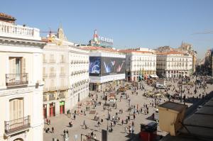 a group of people walking around a city street at Apartamentos Day Madrid CHUECA Centro Gran Via Sol Malasaña in Madrid