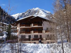 a building in the snow with a mountain in the background at Appartment & Taxi Tirana in Samnaun