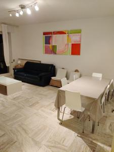 ein Wohnzimmer mit einem Tisch, Stühlen und einem Sofa in der Unterkunft Appartamento per 4 persone - Caray Park - Sale Marasino - Lago d'Iseo in Marone