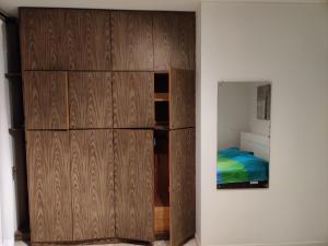 ein Schlafzimmer mit einem großen Holzschrank neben einem Bett in der Unterkunft Appartamento per 4 persone - Caray Park - Sale Marasino - Lago d'Iseo in Marone