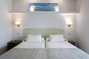 a bedroom with a bed with two white pillows at Hotel Bahía in La Savina