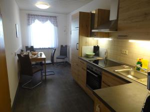 a kitchen with a sink and a table with chairs at Ferienwohnung Bäckerei Förster in Bad Schandau