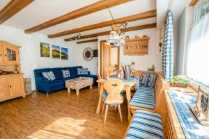 a living room with a blue couch and a table at Ferienwohnung Linderspitzblick in Mittenwald