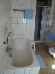 a white bathroom with a tub and a toilet at Ferienwohnung Bäckerei Förster in Bad Schandau
