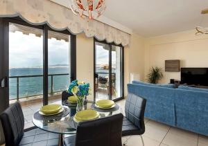 テッサロニキにあるSeafront Family Apartment & free parking, the Cruiseflatのテーブルと椅子とソファのあるダイニングルーム