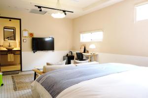 a bedroom with a bed and a tv on a wall at Chill Roof Hotel in Taipei