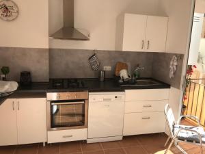 a kitchen with white cabinets and a stove top oven at Ferienwohnung im Zentrum in Alicante