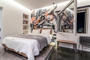 een slaapkamer met een bed en een schilderij aan de muur bij AthinA STREETAPARTMENTS in Athene