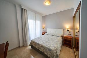 a bedroom with a bed and a dresser and a mirror at Hotel Bajamar Centro in Nerja