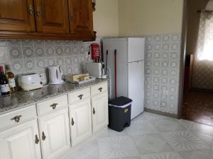 a kitchen with white cabinets and a white refrigerator at Cantinho do Préstimo in Águeda