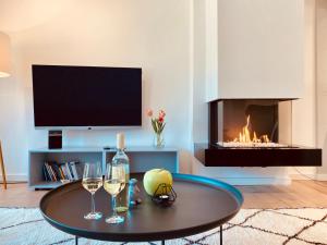 a living room with a fireplace and a table with wine glasses at Prora Düne 7 in Binz