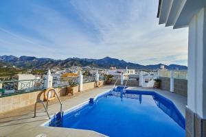 a swimming pool on a balcony with a view of the mountains at Hotel Bajamar Centro in Nerja