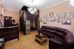 a living room with a leather couch and a table at Inn 6 Line in Saint Petersburg
