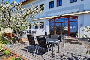 una terrazza in legno con tavolo e sedie. di Hotel Grunt a Mladá Boleslav