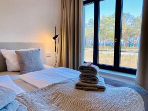 łóżko z stertą ręczników i oknem w obiekcie Prora Düne 7 w mieście Binz