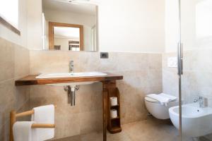 ein Badezimmer mit einem Waschbecken, einem WC und einem Spiegel in der Unterkunft Albergo Locanda Mistral in Acceglio