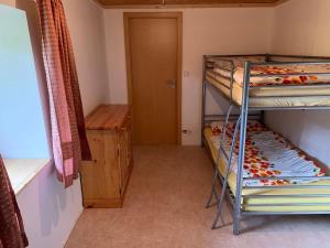 a small room with two bunk beds and a door at Ferienhaus Ramersdorf in Kollnburg