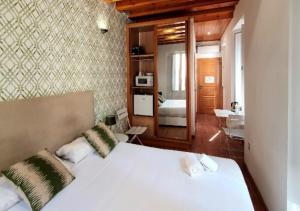 1 dormitorio con 1 cama blanca grande y baño en Mercat Suites, en Valencia