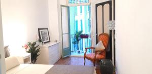 a living room with a chair and a window at Appartements Massena in Nice