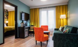 a hotel room with a couch and a chair and a bed at Thon Hotel Bristol, Bergen in Bergen