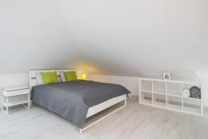 a white bedroom with a bed with green pillows at Apartment Alexander in Krakow