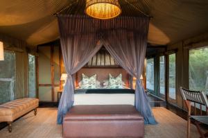 מיטה או מיטות בחדר ב-HillsNek Safari Camp – Amakhala Game Reserve