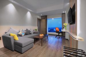 a living room with a couch and a table at Harper Wahid Hasyim Medan by ASTON in Medan