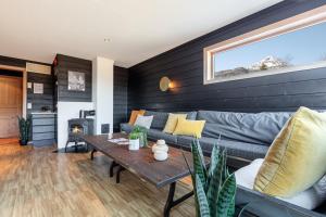 Skiers Lodge 2 - Saga Apartments في هيمسيدال: غرفة معيشة مع أريكة وطاولة