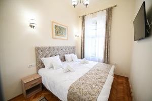 a bedroom with a large bed with white sheets at Casa ABA in Sibiu